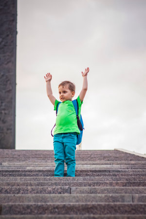 Portrait of a child, a boy against the backdrop of urban landscapes of skyscrapers and high-rise buildings in the open air. children, travel. Lifestyle in the city. Center, streets. Summer, a walk.の写真素材