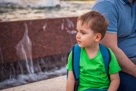 Portrait of a child, a boy against the backdrop of urban landscapes of skyscrapers and high-rise buildings in the open air. children, travel. Lifestyle in the city. Center, streets. Summer, a walk.の写真素材