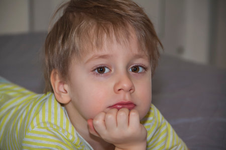 A cute boy in a striped T-shirt. Portrait of a blond boy in a natural setting. The face expresses natural emotions. Not staged photos from nature.の写真素材