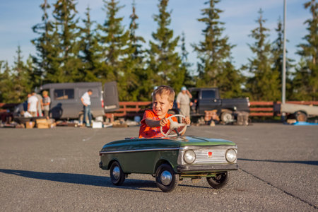 2022-08-12 Tatarstan, Verkhneuslonsky district, village. Savino. Resort town "Sviyazhsky hills". Kazan Festival of Historical Technologies. Children ride on children's retro cars.のeditorial素材