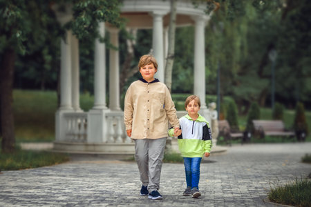 Two brothers, two Young handsome boys of European appearance, enjoy spending time on the street. It's a great time to relax. Portrait of a child.の写真素材