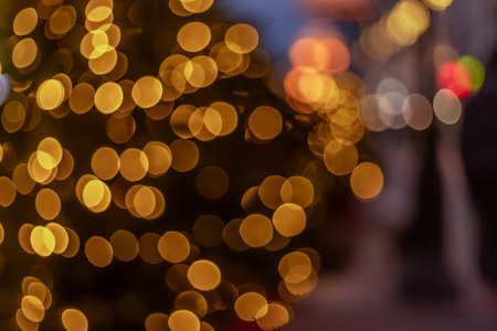 Out-of-focus circular lights create a warm bokeh effect in golden hues. The blurred background enhances the artistic aesthetic, evoking a festive and cozy atmosphereの写真素材
