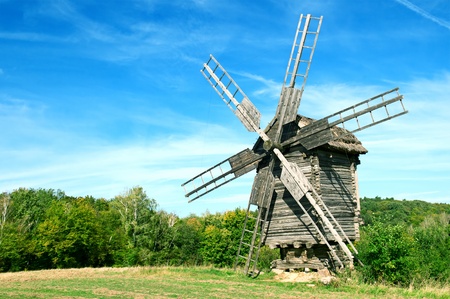 Old wooden windmill in the background of the autumn forestの写真素材