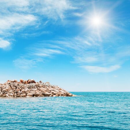 sea, rocky shore and blue skyの写真素材