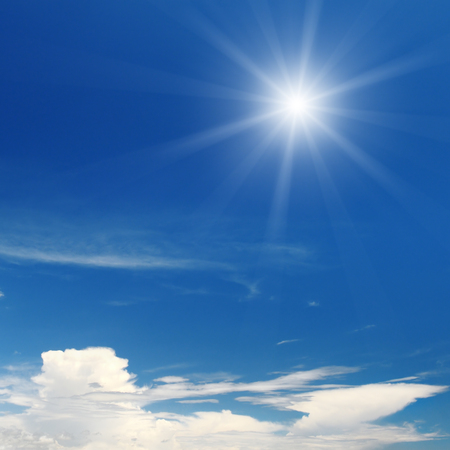 sun on blue sky with white cloudsの写真素材