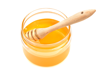 pot with honey and drizzler isolation  on a white backgroundの写真素材
