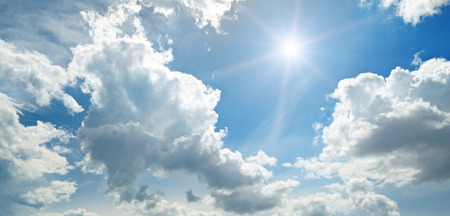 sun on blue sky with white cloudsの写真素材