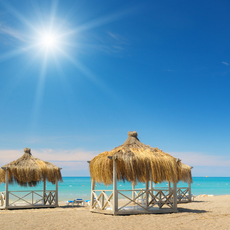 Beach, bungalows, blue sky and sunの写真素材