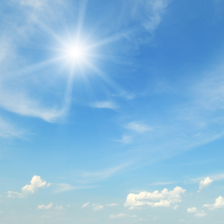 sun on blue sky with white cloudsの写真素材