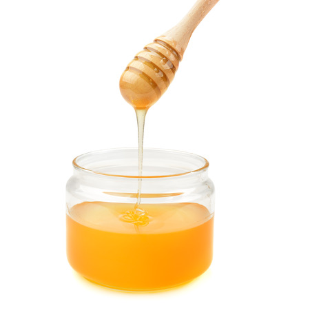pot with honey and drizzler isolation on a white backgroundの写真素材