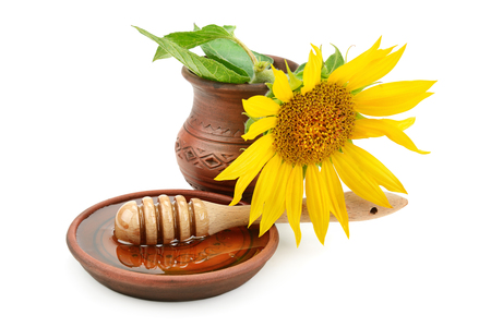 clay dish with honey drizzler and flowers sunflowersの写真素材