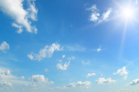 sun on blue sky with white cloudsの写真素材
