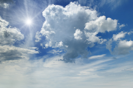 sun on blue sky with white cloudsの写真素材