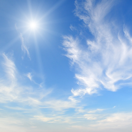 sun on blue sky with white cloudsの写真素材