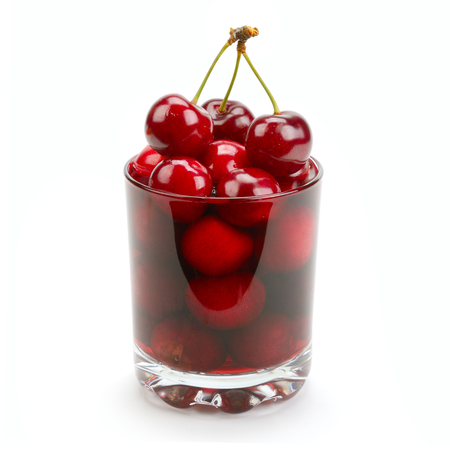 cherry and glass of juice isolated on white backgroundの写真素材