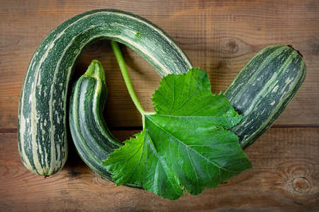 Fresh healthy green zucchini courgettes in brown wooden backgroundの写真素材