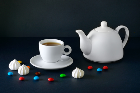 White cup and teapot on a black background.の写真素材