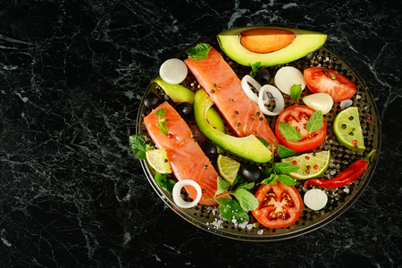 Fillet of red fish and spices on a black background. Free space for text.の写真素材