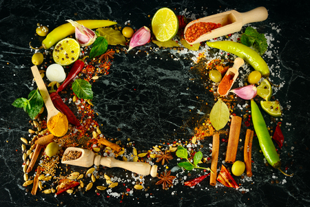 Variety of spices and herbs on kitchen table. Flat lay, top view. Free space for text.の写真素材