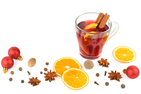 Hot red mulled wine isolated on white background with christmas spices, orange slice, anise and cinnamon sticks, close up. Flat lay, top view. Free space for text.の写真素材