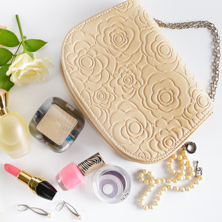 Cosmetics, perfumes, jewelry made of pearls and handbag on a white background. Flat lay, top view.の写真素材