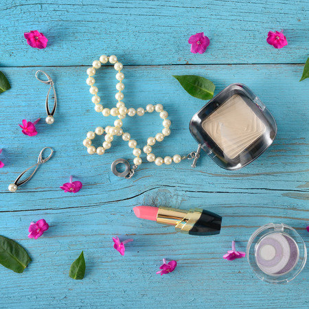 Decorative cosmetics and jewelry made of pearls on an old wooden background of blue color. Flat lay, top view. Free space for text.の写真素材
