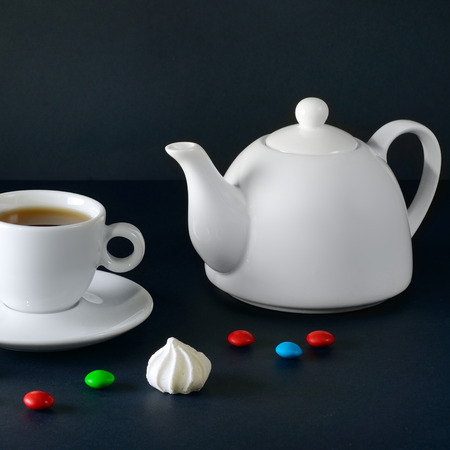 White cup and teapot on a black background.の写真素材
