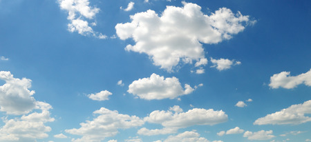 Light cumulus clouds against the blue sky. A bright sunny day. Wide photo.の写真素材