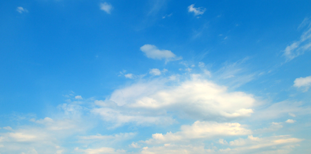 Light cumulus clouds against the blue sky. A bright sunny day. Wide photo.の写真素材