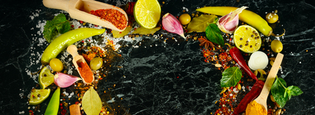 Variety of spices and herbs on kitchen table. Flat lay, top view. Free space for text. Wide photo.の写真素材