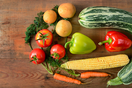 A set of vegetables laid out on a wooden table. Flat lay,top view. Free space for text.の写真素材