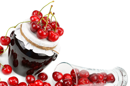 Cherries and jars of jam isolated on a white background. Free space for text.の写真素材