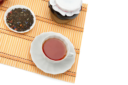 Cup of tea, jam jar and tea leaves isolated on white background. Flat lay, top view. Free space for text.の写真素材