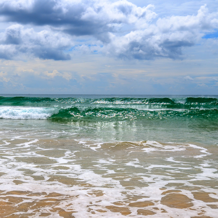 Dramatic cloudscape with heavy rain and tropical storm at the horizon on the coastline of Sri Lanka. Wide angle shot frome the sandy beach.の写真素材