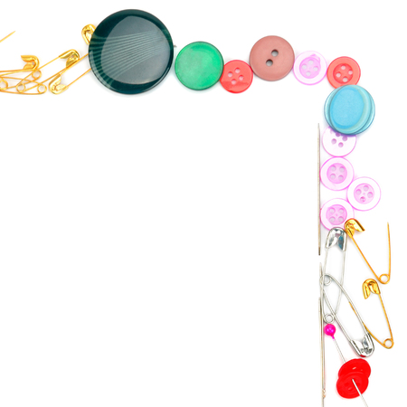 Sewing accessories isolated on white background. Colorful frame of buttons and needles. Free space for text.の写真素材