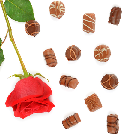 Assortment of chocolate candies and red rose isolated on white background. Flat lay, top view.の写真素材