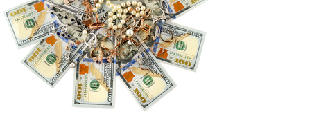 Gold jewelry and dollars isolated on white background. Flat lay, top view. Free space for text.Wide photo.の写真素材