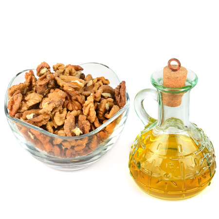 Oil of walnut and nut fruit isolated on white background. Free space for text.の写真素材