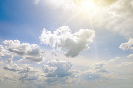 Bright sun on blue sky with white clouds.の写真素材