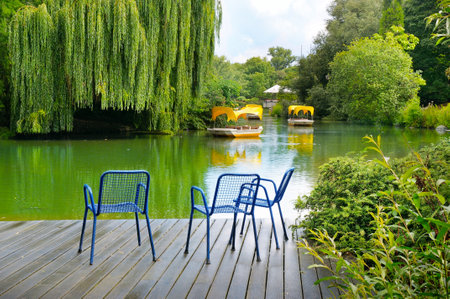 A wooden pier is a platform on a lake in the city park. Comfortable seating area.のeditorial素材