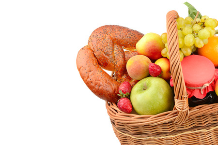 Organic food isolated on white background. A set of fruits and pastries in a woven basket. Free space for text.の写真素材