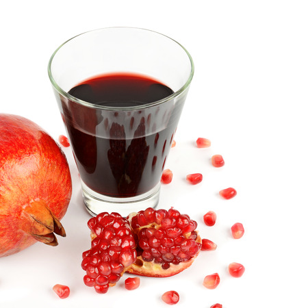 Glass of pomegranate juice with fruit isolated on white. Free space for text.の写真素材