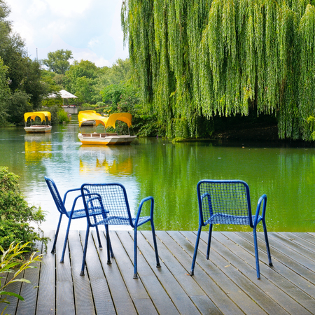 A wooden pier is a platform on a lake in the city park. Comfortable seating area.の写真素材