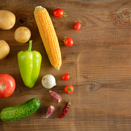 A set of vegetables laid out on a wooden table. Flat lay,top view. Free space for text.の写真素材