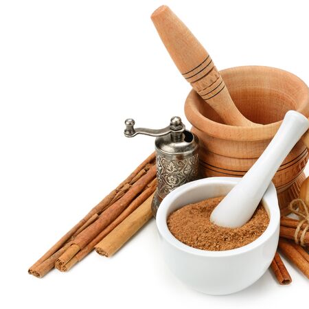 Cinnamon, mortar and pestle, hand grinder isolated on white background. Healthy food. Free space for text.の写真素材