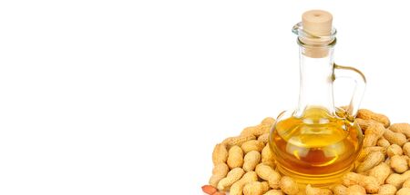Peanuts and oil in bottle isolated on white background. Organic food. Free space for text. Wide photo.の写真素材