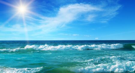 Seascape and sun on blue sky background. Wide photo.の写真素材