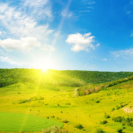 Hilly field, sunrise and blue sky.の写真素材