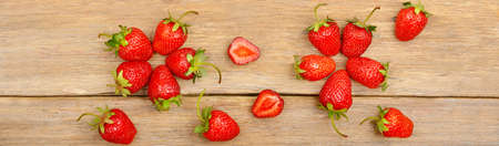 Ripe red strawberries on a wooden table. Wide photo.の写真素材