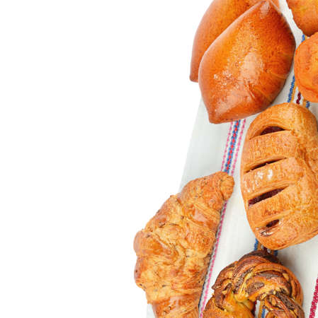Croissant, muffin and other sweet pastries on rustic napkin isolated on white background. Place for your text.の写真素材